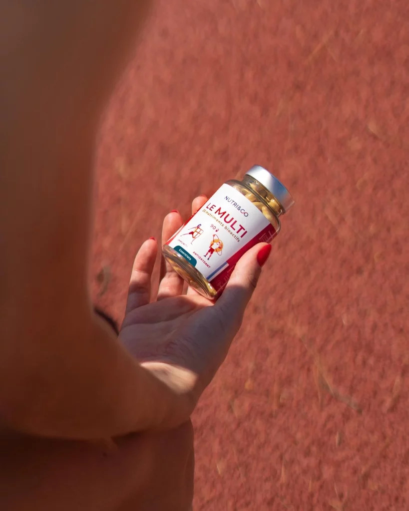 une personne tenant la multivitamines et minéraux nutri&co dans sa main